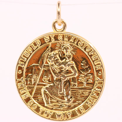A round gold Saint Christopher medal pendant with a polished bail, featuring an embossed depiction of Saint Christopher carrying the Christ child across water, set against a plain white background.