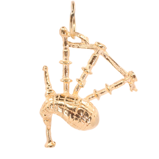 A gold-colored metal pendant shaped like a traditional Scottish bagpipe, featuring a textured body and legs, hanging against a plain white background.