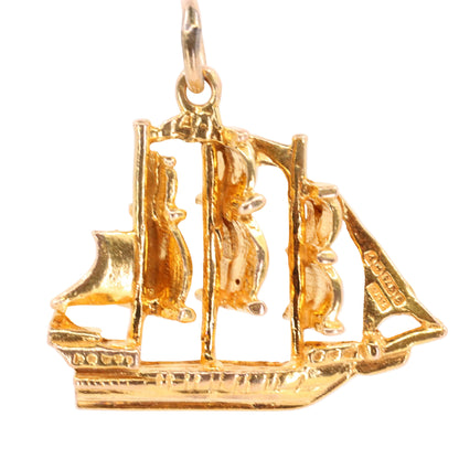 A gold ship pendant charm with three masts and a top hanging loop, shown against a plain white background.