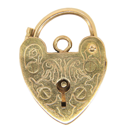 A small antique-style heart-shaped gold padlock pendant with engraved floral patterns and a keyhole cutout, shown on a plain light background.