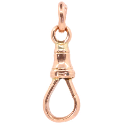A polished rose gold lobster clasp pendant charm, shown against a solid pale pink background.